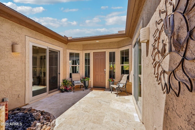 property entrance featuring a patio area and stucco siding
