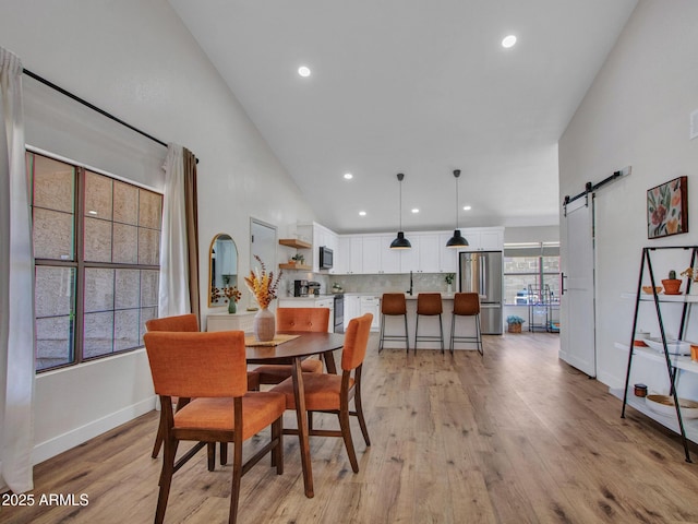12641 S 39th Pl, Phoenix, AZ 85044 - dining space with a barn door, light wood-style flooring, and recessed lighting