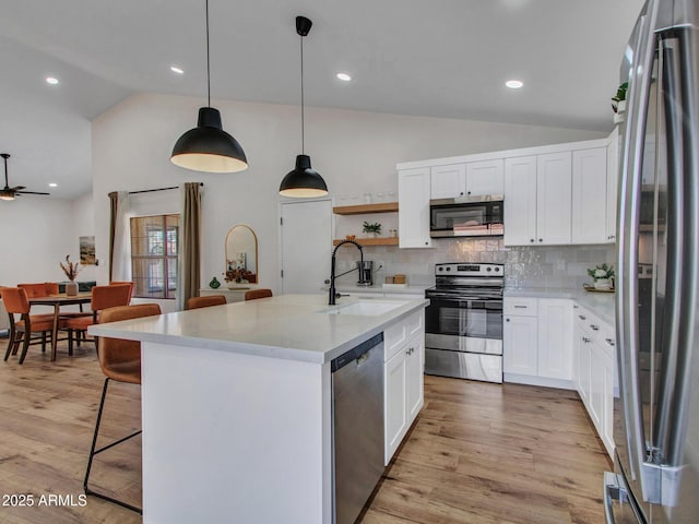 12641 S 39th Pl, Phoenix, AZ 85044 - kitchen with stainless steel appliances, vaulted ceiling, tasteful backsplash, light wood-style flooring, and white cabinets