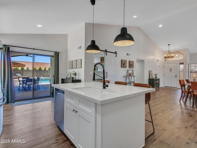 12641 S 39th Pl, Phoenix, AZ 85044 - kitchen featuring high vaulted ceiling, dishwasher, white cabinetry, a barn door, and light wood finished floors