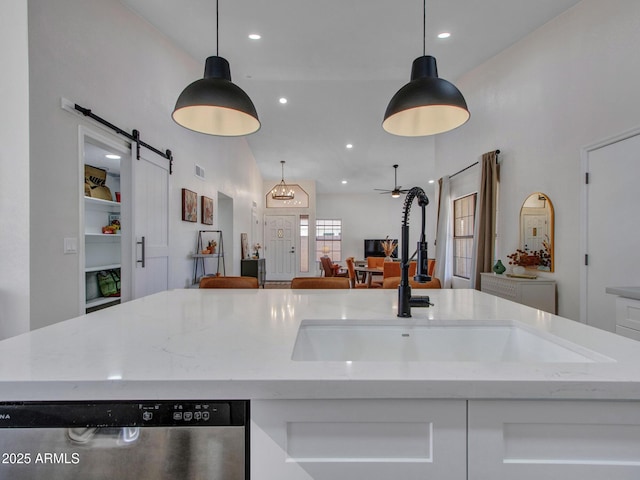 12641 S 39th Pl, Phoenix, AZ 85044 - kitchen with a barn door, open floor plan, stainless steel dishwasher, hanging light fixtures, and light stone counters