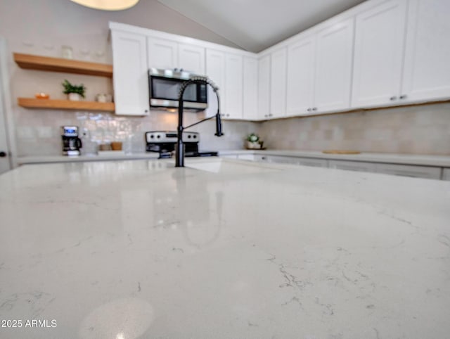 12641 S 39th Pl, Phoenix, AZ 85044 - kitchen with stainless steel microwave, electric range oven, white cabinets, vaulted ceiling, and decorative backsplash