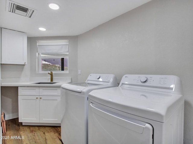 12641 S 39th Pl, Phoenix, AZ 85044 - laundry room with washer and clothes dryer, light wood-style floors, and cabinet space