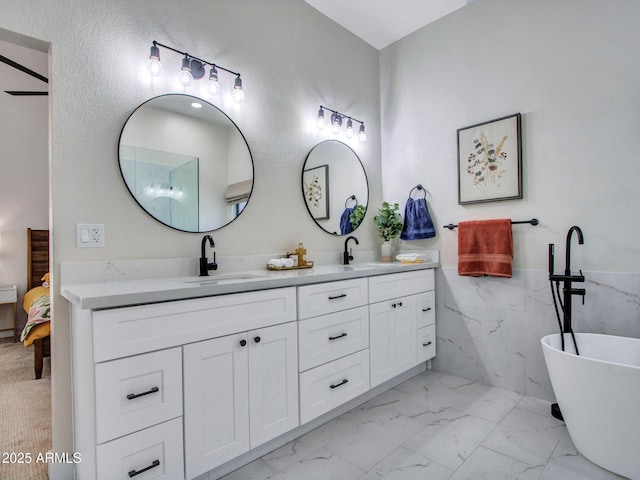 12641 S 39th Pl, Phoenix, AZ 85044 - ensuite bathroom with marble finish flooring, double vanity, a freestanding bath, tile walls, and wainscoting