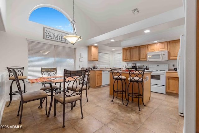 dining area with light tile patterned floors, recessed lighting, visible vents, and a towering ceiling