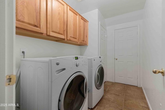 clothes washing area with cabinet space, tile patterned flooring, washer and dryer, and baseboards