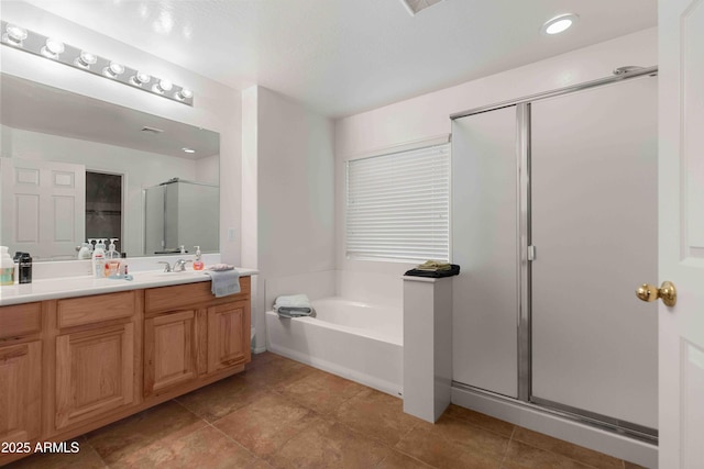 bathroom featuring vanity, a bath, a shower stall, and tile patterned flooring