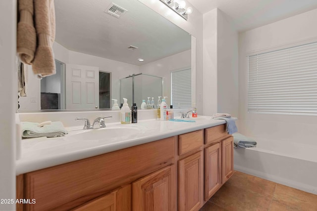 full bath with double vanity, a stall shower, a sink, a garden tub, and tile patterned floors