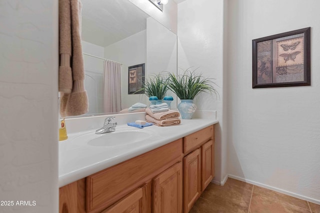 bathroom with curtained shower, baseboards, and vanity