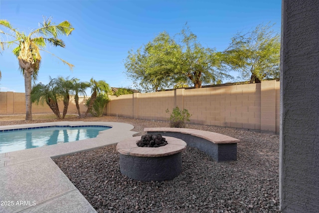 view of swimming pool featuring a patio, a fenced backyard, a fenced in pool, and an outdoor fire pit