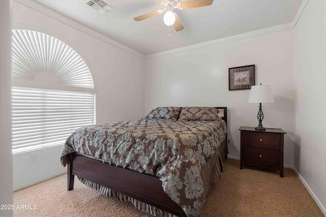 bedroom featuring baseboards, visible vents, carpet floors, ceiling fan, and crown molding