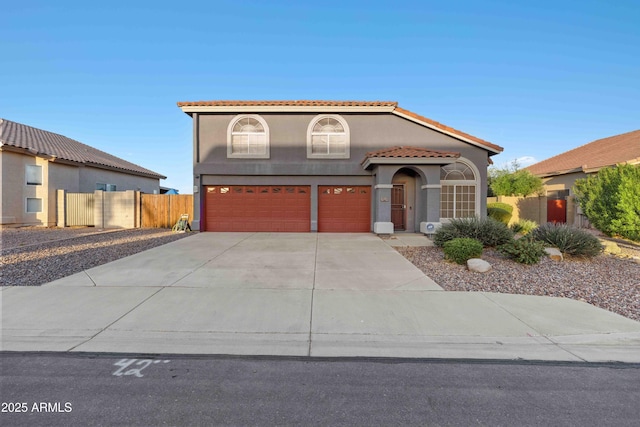 mediterranean / spanish-style house featuring fence, driveway, an attached garage, stucco siding, and a tile roof