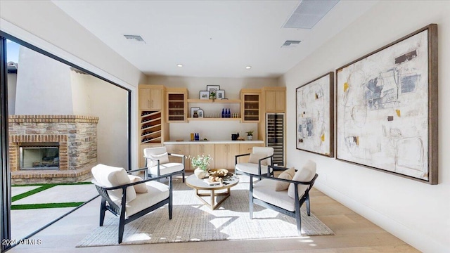 living area with light wood-type flooring and a brick fireplace