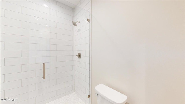 bathroom featuring toilet and a shower with door