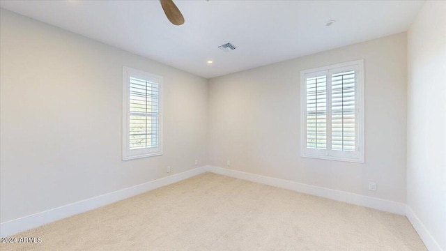 carpeted empty room featuring ceiling fan and a wealth of natural light