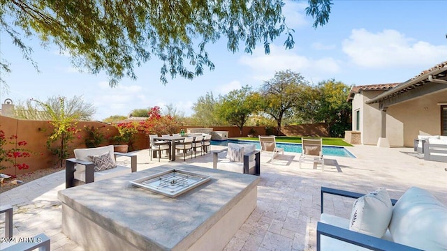 view of patio / terrace with a fenced in pool and an outdoor fire pit