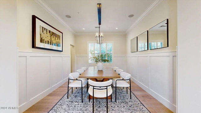 dining room featuring a chandelier, light hardwood / wood-style flooring, and crown molding