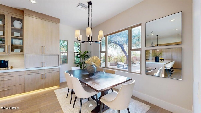 dining space featuring light wood-type flooring and a chandelier