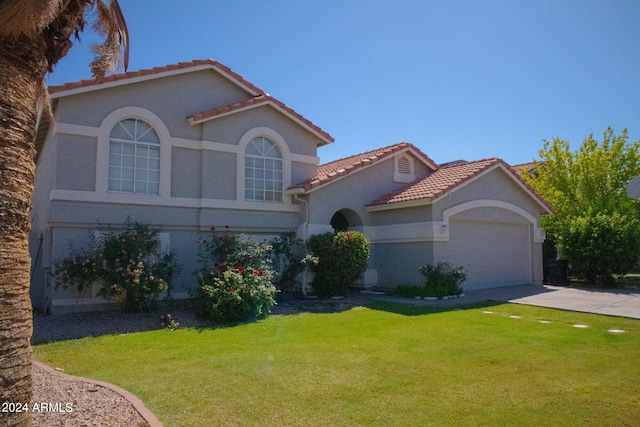 mediterranean / spanish house with a front lawn and a garage