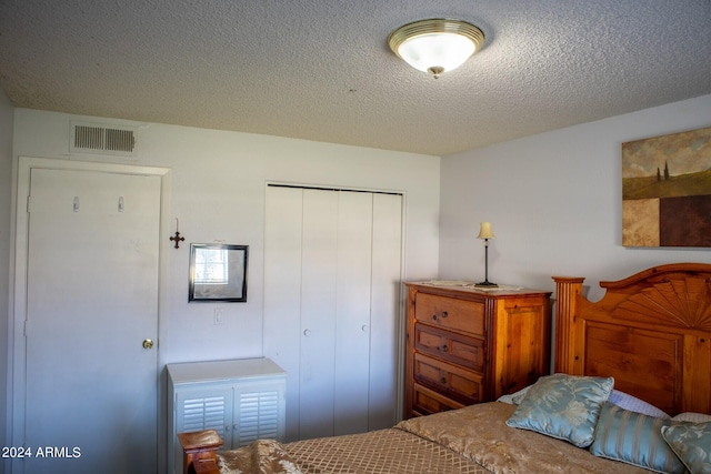 bedroom with a textured ceiling and a closet