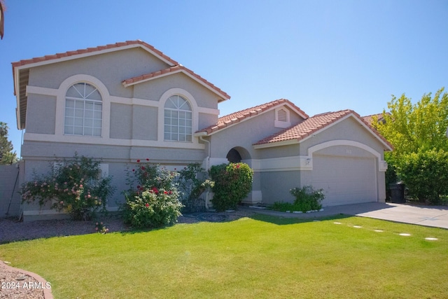 mediterranean / spanish house featuring a front yard and a garage