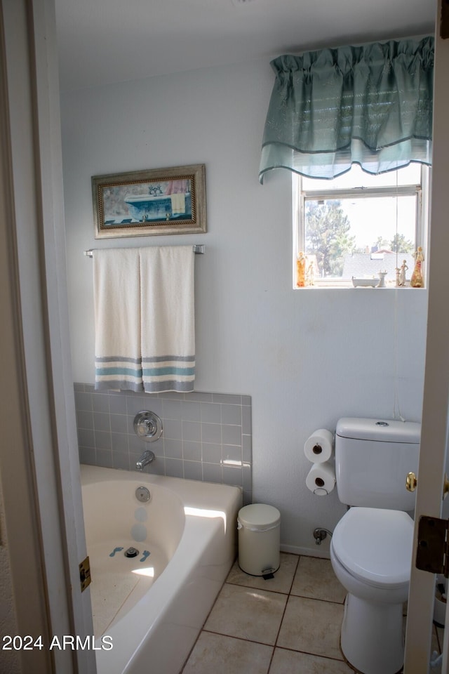 bathroom with tile patterned flooring, toilet, and a tub