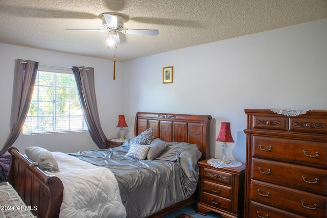 bedroom with ceiling fan and a textured ceiling