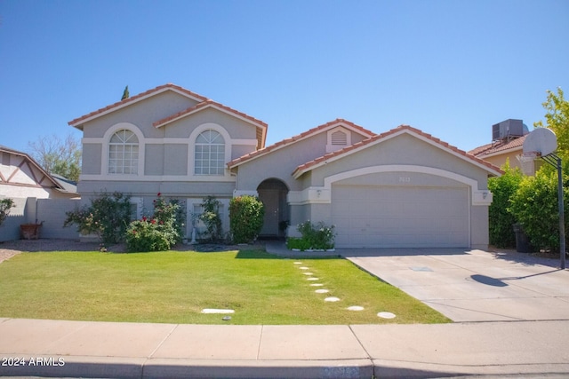 mediterranean / spanish house featuring a garage and a front yard