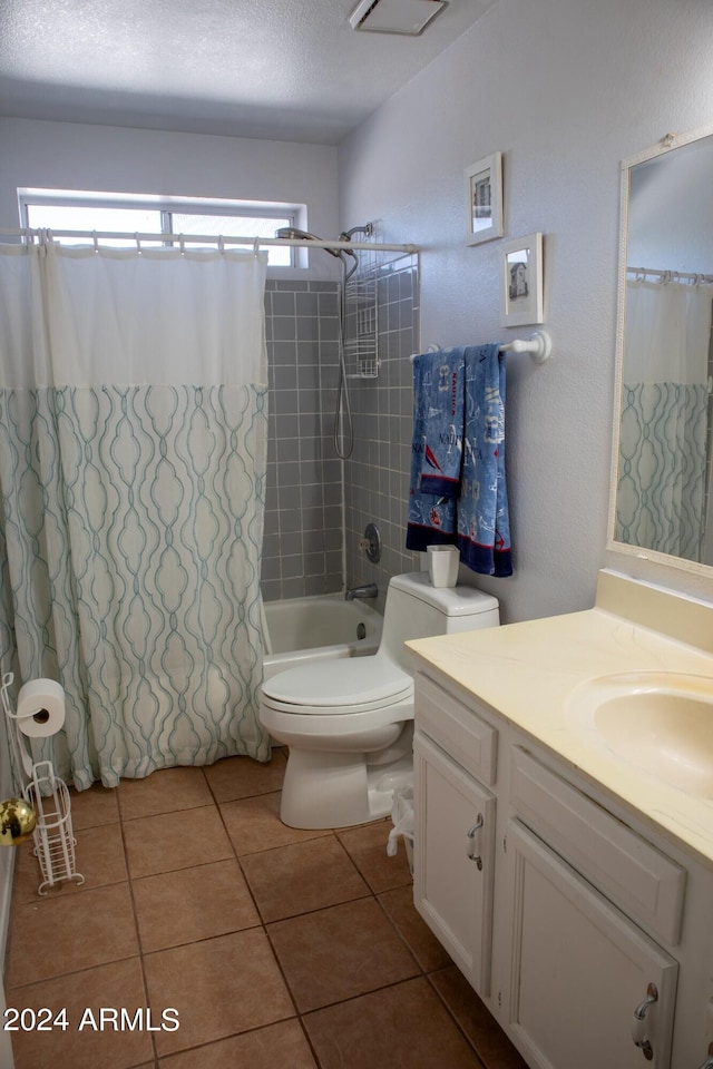 full bathroom featuring tile patterned floors, vanity, a textured ceiling, shower / tub combo with curtain, and toilet