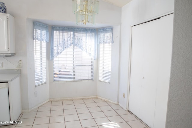 unfurnished dining area featuring light tile patterned floors and an inviting chandelier