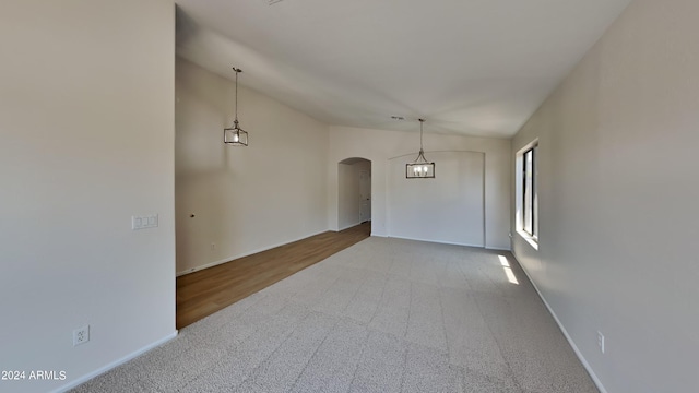 empty room featuring hardwood / wood-style flooring and lofted ceiling