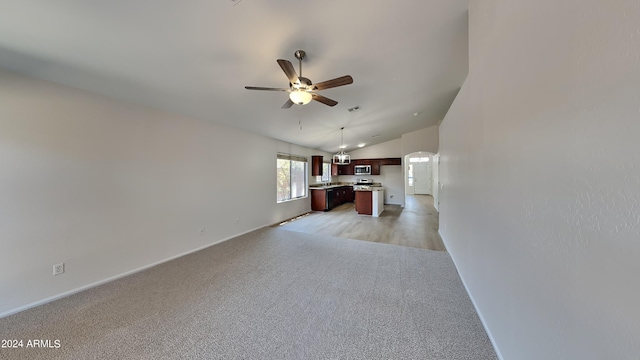 unfurnished living room with ceiling fan with notable chandelier, lofted ceiling, and light hardwood / wood-style flooring