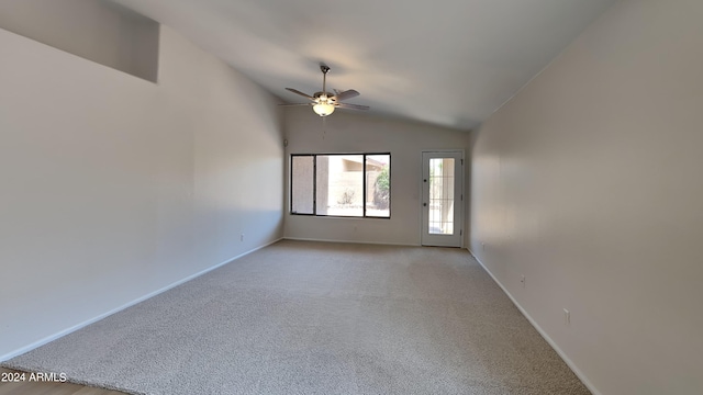 empty room featuring lofted ceiling, ceiling fan, and light colored carpet