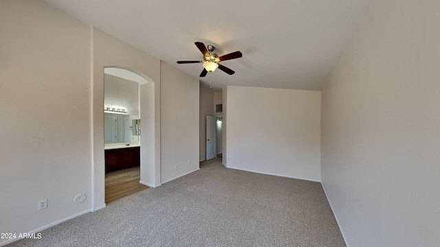 unfurnished bedroom with connected bathroom, ceiling fan, and light colored carpet