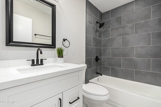 full bathroom featuring tiled shower / bath combo, toilet, and vanity