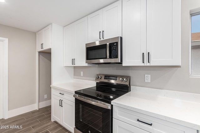 kitchen featuring light stone counters, white cabinets, and appliances with stainless steel finishes