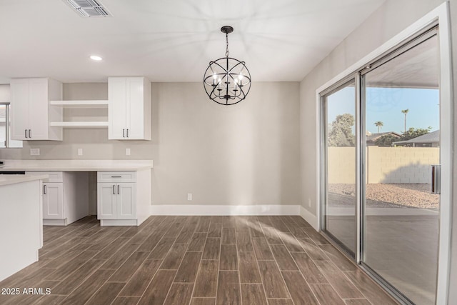 kitchen featuring pendant lighting, white cabinetry, and a notable chandelier