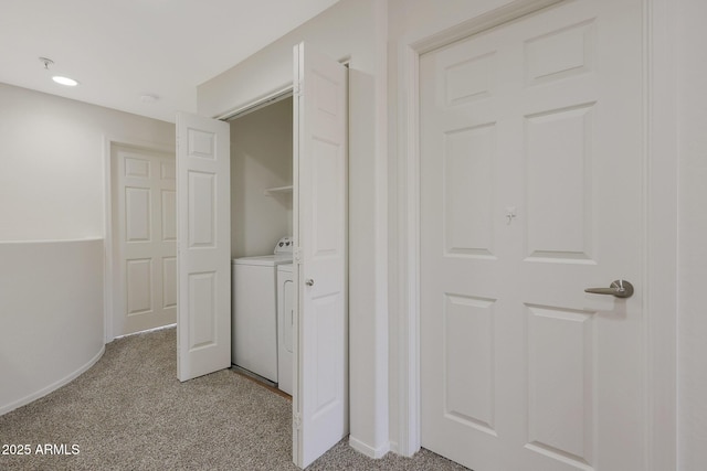 corridor featuring washer / clothes dryer and light colored carpet