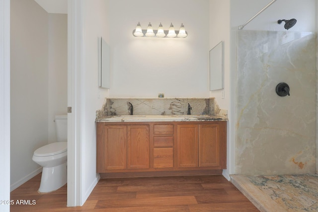 bathroom with a shower, vanity, wood-type flooring, and toilet