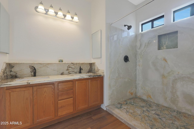 bathroom featuring hardwood / wood-style floors, vanity, and walk in shower