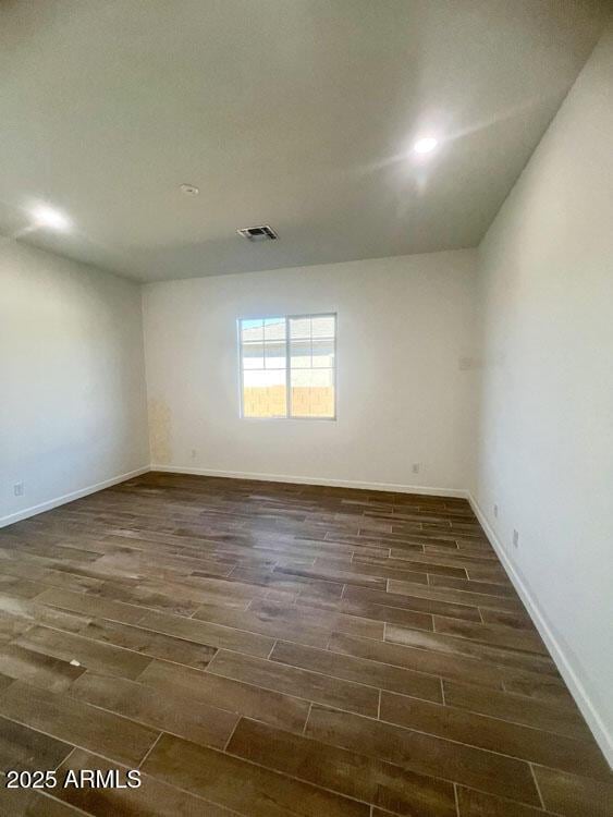 unfurnished room featuring visible vents, baseboards, and wood finish floors