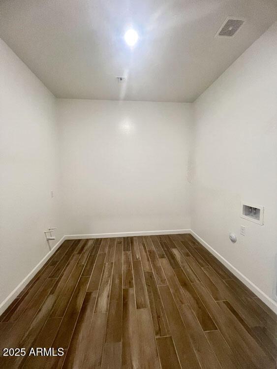 spare room featuring dark wood finished floors, baseboards, and visible vents