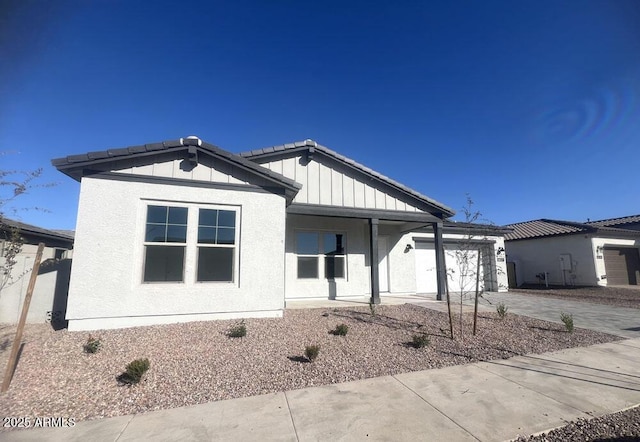 view of front of property featuring a garage, stucco siding, driveway, and board and batten siding