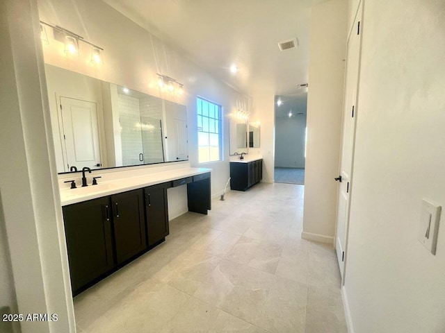 full bathroom featuring a shower stall, two vanities, visible vents, and a sink