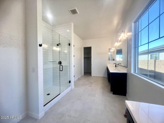 bathroom with visible vents, baseboards, vanity, and a shower stall