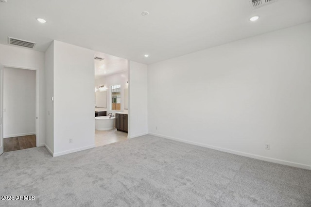 unfurnished room featuring recessed lighting, light colored carpet, visible vents, and baseboards