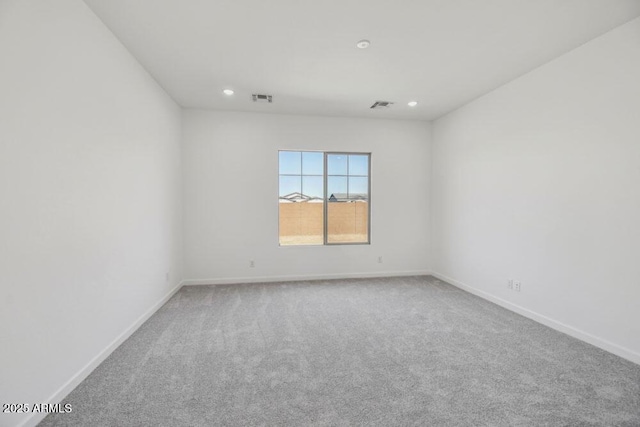 carpeted empty room featuring recessed lighting, visible vents, and baseboards