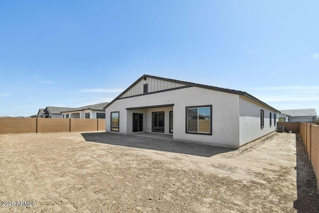 back of house with a fenced backyard and stucco siding