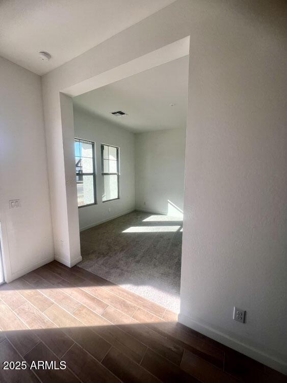 unfurnished room featuring visible vents and wood finish floors