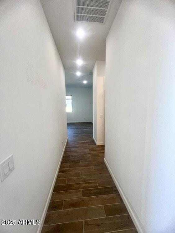 corridor with baseboards, visible vents, and wood finish floors